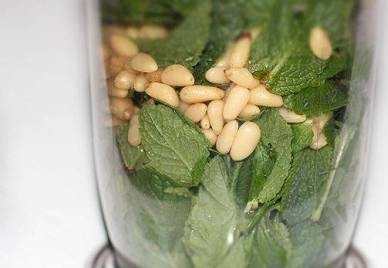 1. Этап. Соус к говядине: Перекладываем листья мяты в чашу блендера, добавляем очищенные кедровые орешки. По желанию примерно столовую ложку орешков можно оставить и добавить уже в готовый соус.