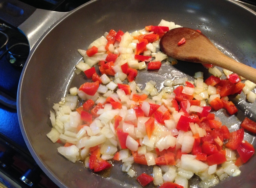 1. Этап. Томатная подлива: Порежьте лук и болгарский перец небольшими кубиками. Разогрейте на сковороде растительное масло, добавьте сначала лук, обжарьте до мягкости. Потом добавьте перец и перемешайте. Обжаривайте на среднем огне минуты 3-4.