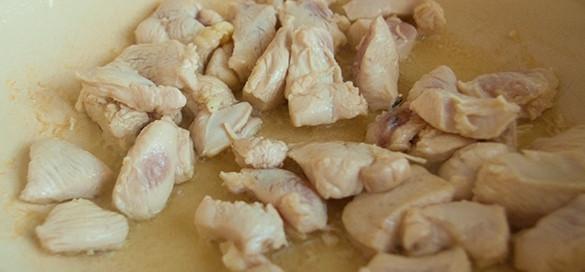 1. Этап. Рисовая лапша с овощами и курицей: В сковороду влейте немного растительного масла, поставьте ее на плиту. Когда масло разогреется, обжарьте на нем кусочки курицы на среднем огне до золотистого оттенка.