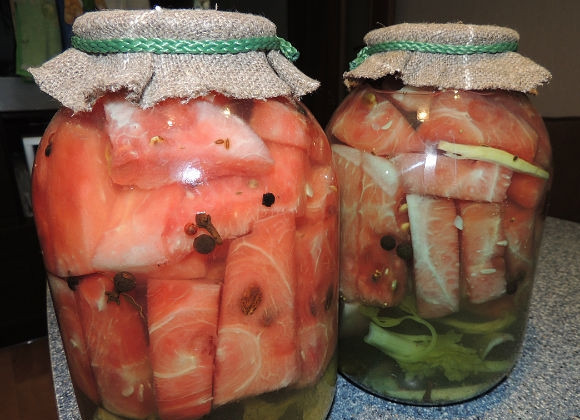 1. Этап. Маринованные арбузы в банках: Перед тем как закупорить маринованный арбуз в банки, в маринад можно добавить несколько горошин чёрного перца и гвоздику по вкусу. Разложите арбуз по банкам, залейте маринадом. Затем заготовку можно плотно закупорить крышкой или же закатать привычным способом.