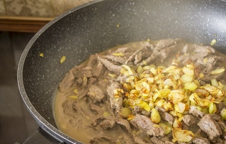 1. Этап. Говядина с луком и сметаной: Жарим, помешивая, до тех пор, пока мясо не потемнеет со всех сторон. И добавляем обжаренные лук с чесноком.