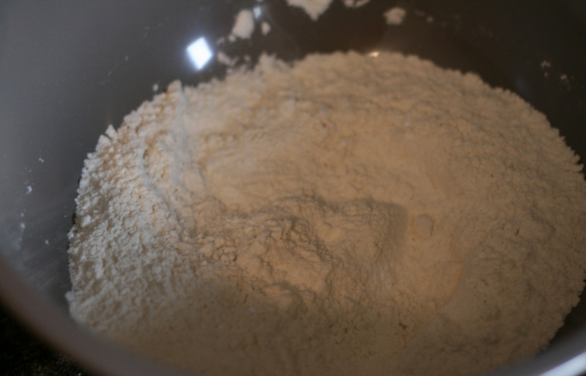 1. Этап. Пышные оладушки на молоке: Просейте муку, добавьте в нее разрыхлитель, пекарский порошок, сахар и соль. Смешайте сухие ингредиенты.