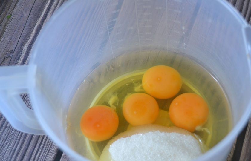 1. Этап. Бисквитный рулет с яблоками: В емкость для взбивания положите 4 яйца, всыпьте сахар.