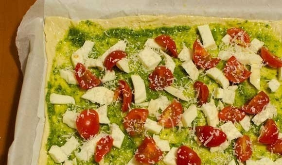 1. Этап. Пицца с песто и томатами: 2. Выложите нарезанные помидоры черри и немного тертого сыра пармезан.