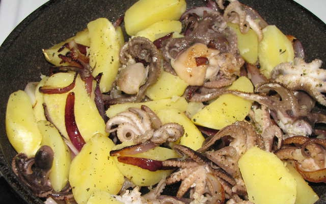 1. Этап. Салат из осьминога с картофелем: На сковородке обжариваем лук, пока он не станет золотистым. Это займет 7 минут. Затем бросаем осьминогов, приправляем солью и орегано. Обжариваем 5 минут. После чего добавляем отварную картошку. Перемешиваем и обжариваем пару минут.