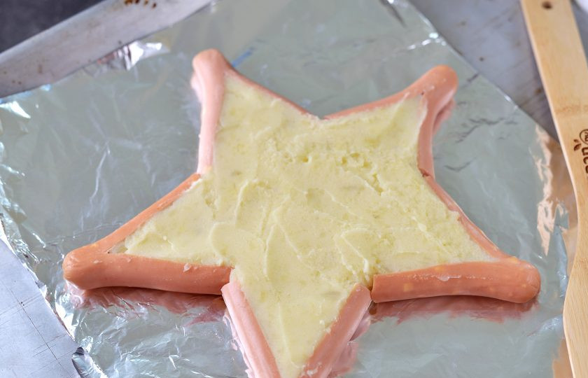 1. Этап. Звезды из сосисок и картофельного пюре: Заполните звезду из сосисок картофельным пюре, разровняйте внешней стороной столовой ложки.