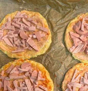 1. Этап. Мини пиццы на творожной основе: Сверху на каждую основу выложить измельченные ветчину и сосиски