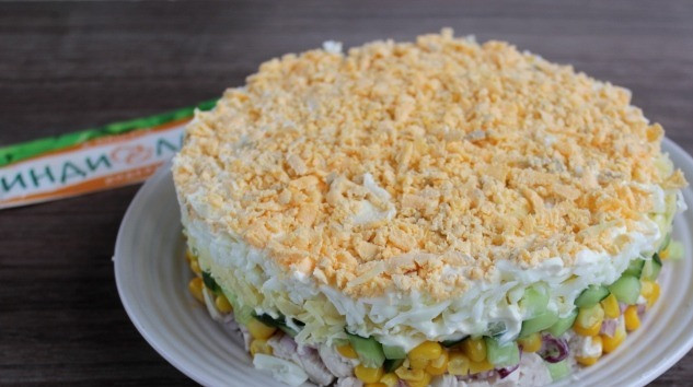 1. Этап. Новогодний салат Символ года: Далее выложить кукурузу и огурец, нанести майонезную сетку. Следующий слой - натертый сыр, натертый белок + майонез, сверху яичный желток.