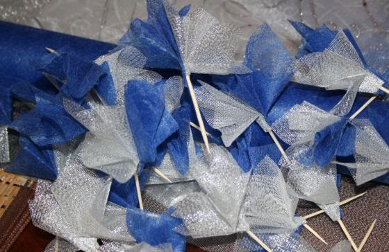 1. Этап. Ежик из конфет: 3. Цветовая гамма, в которой будет сделан ежик из конфет в домашних условиях может быть абсолютно любой. Лучше сочетать 2-3 цвета. Из фатина или огранзы необходимо сделать небольшие заготовки (кулечки или фунтики), посадив их на зубочистку и приклеив края.