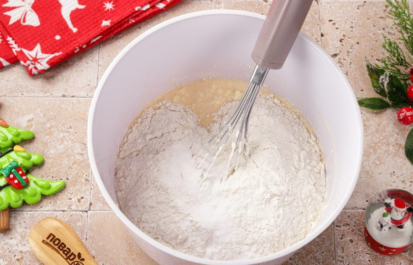 1. Этап. Новогодний торт Зеленая Змея: Добавьте примерно 2/3 части муки и соду, погашенную лимонным соком или уксусом. Перемешайте, а затем частями добавьте оставшуюся муку. Возможно у вас муки уйдёт чуть больше или меньше.