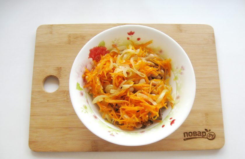 1. Этап. Салат с куриной печенью и фасолью: Выложите в салат лук с морковью.