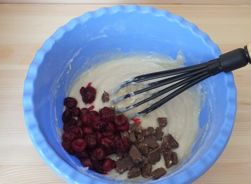 1. Этап. Кекс с вишней в мультиварке: Шоколад поломайте на произвольные кусочки. С вишни слейте лишнюю жидкость. Всё добавьте в тесто и аккуратно перемешайте.