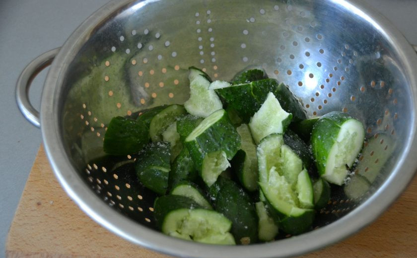 1. Этап. Битые огурцы по-китайски: Нарежьте огурцы на кусочки примерно по 2 см. Выложите в дуршлаг, посолите, оставьте на 10 минут, после чего встряхните, чтобы слить образовавшийся сок.