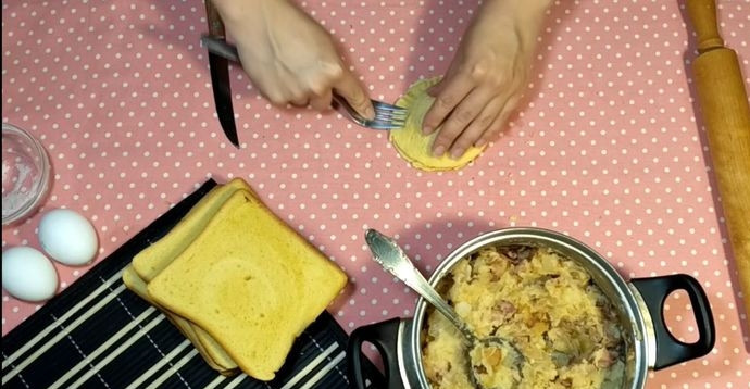 1. Этап. Лентяйские пирожки из хлеба: 6. Выложите на одну часть хлеба начинку, накройте второй частью, прижмите края вилкой.