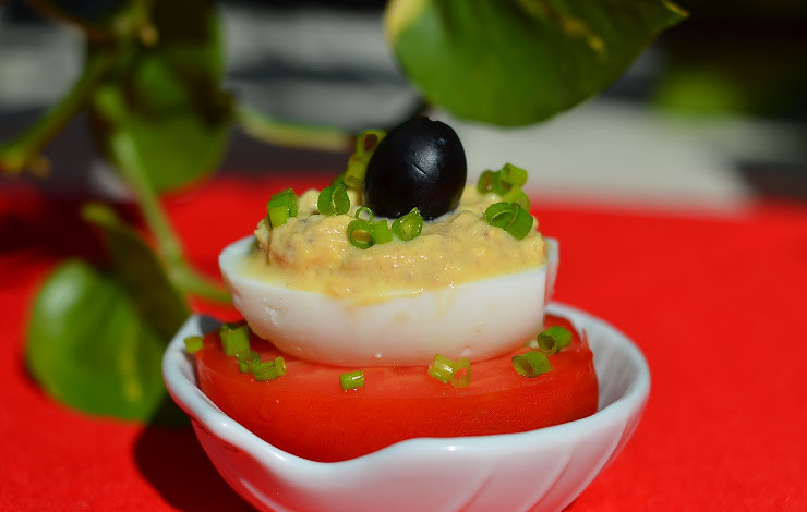 1. Этап. яйца Мимоза: А теперь формируем непосредственно само блюдо. Берем помидоры, разрезаем их пополам, аккуратно удаляем сердцевину. Оставшиеся от яиц белки аккуратно наполняем сделанной начинкой. Белки вставляем в помидоры. Сверху всю эту конструкцию украшаем измельченным зеленым лучком и маслиной.