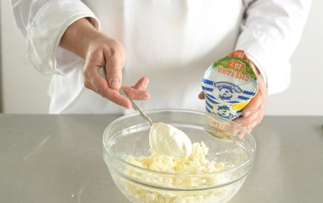 1. Этап. Творожное тесто без дрожжей: Сливочное масло растопите до жидкого состояния или же доведите до комнатной температуры. Творог пересыпьте в стеклянную емкость с высокими бортиками. Отправьте к нему масло.