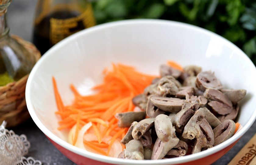 1. Этап. Холодная закуска из куриных сердечек в чесночно-соевом соусе: Остывшие сердечки разрежьте пополам, добавьте к овощам.