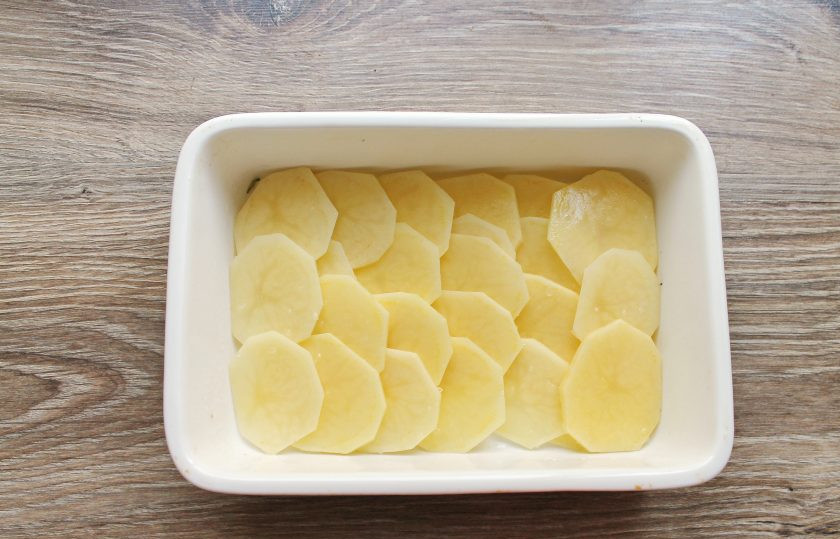 1. Этап. Гратен с беконом: На дно формы для запекания 19*16 сантиметров уложите картофель одним слоем внахлест.