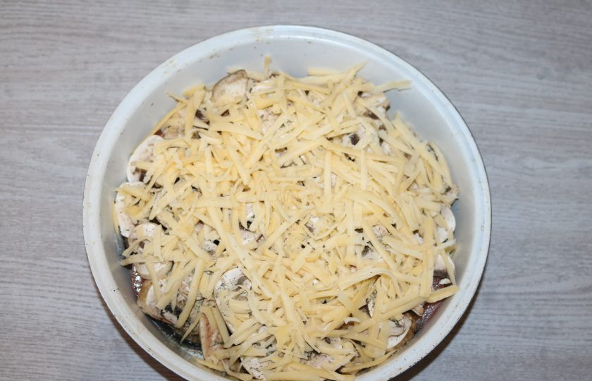 1. Этап. Запеканка с грибами и баклажанами: Сверху натрите сыр на крупной тёрке. Отправьте в разогретую духовку до 200 градусов.