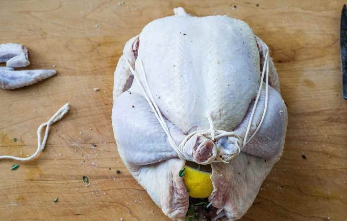 1. Этап. Запеченная курица с морковью: 4. Обвяжите тушку, чтобы закрепить ноги.