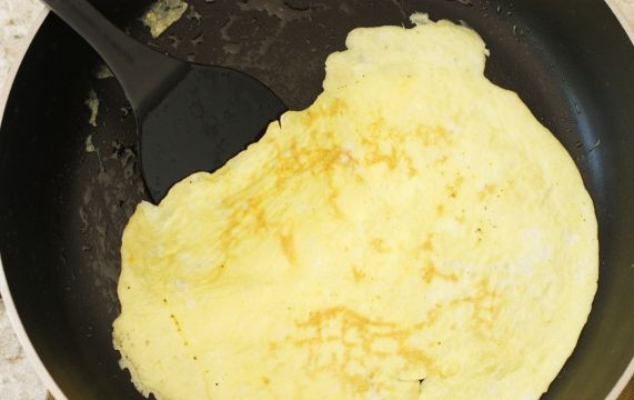 1. Этап. Отварной рис с омлетом и овощами: 2. На сковороде с ложкой масла обжарьте омлет с двух сторон до легкой румяности.