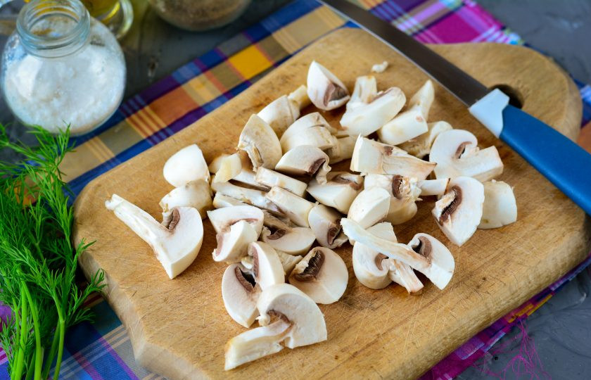 1. Этап. Салат с жареными крабовыми палочками: Нарежьте шампиньоны средними кусочками.