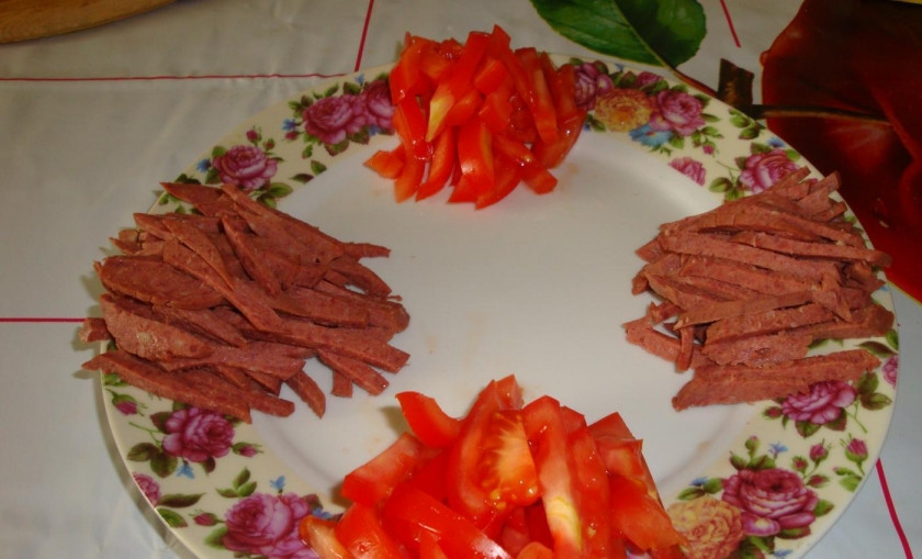 1. Этап. Салат Радуга: Колбасу нарежьте соломкой. Выложите на салатницу двумя горочками друг напротив друга.