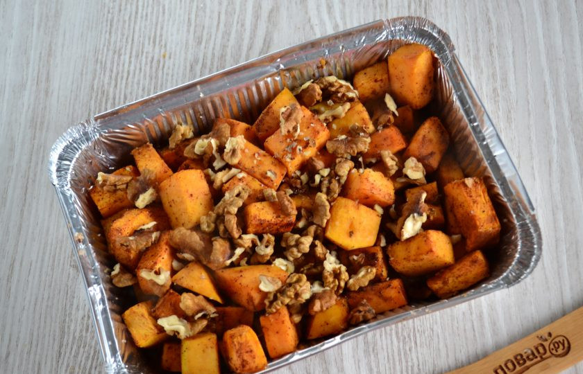 1. Этап. Тыква в сметанном соусе в духовке: Запеките тыкву в духовке при температуре 190 градусов в течение примерно 20 минут. Затем извлеките форму из духовки, добавьте орехи. Их можно измельчить в крошку, а можно оставить достаточно крупными.