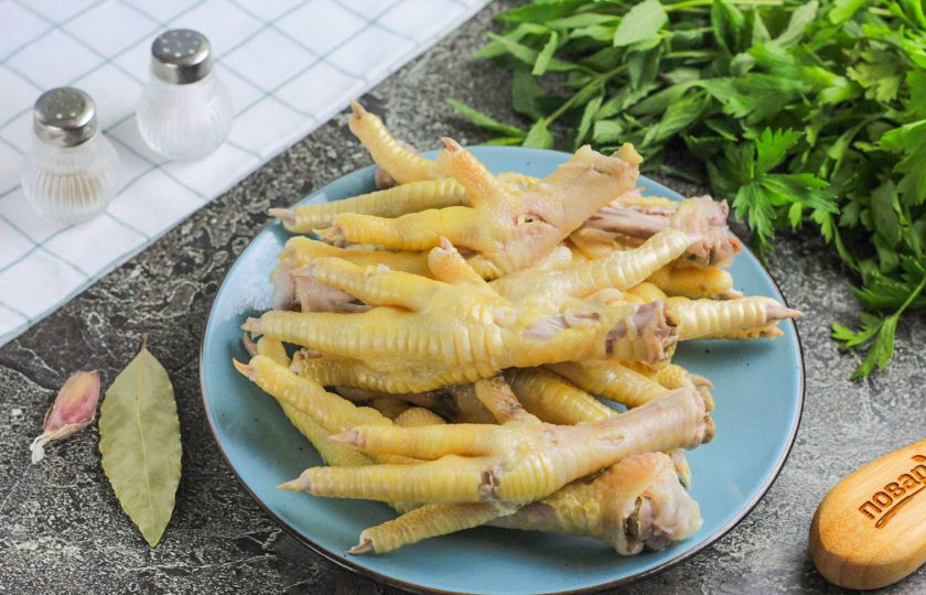 1. Этап. Закуска из куриных лапок: Выложите их из бульона на тарелку и проверьте готовность — они должны стать мягкими. Сильно разваривать их не нужно, чтобы они сохранили свою форму.