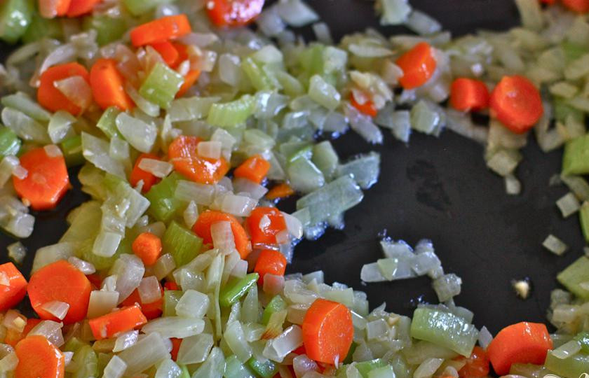 1. Этап. Куриный кассероль с лапшой: 3. Мелко нарезать лук, морковь и сельдерей. Пропустить чеснок через пресс. Измельчить крекеры. В кастрюле нагреть сливочное масло и поджарить лук, чеснок, морковь и сельдерей. Жарить, пока лук не станет прозрачным.