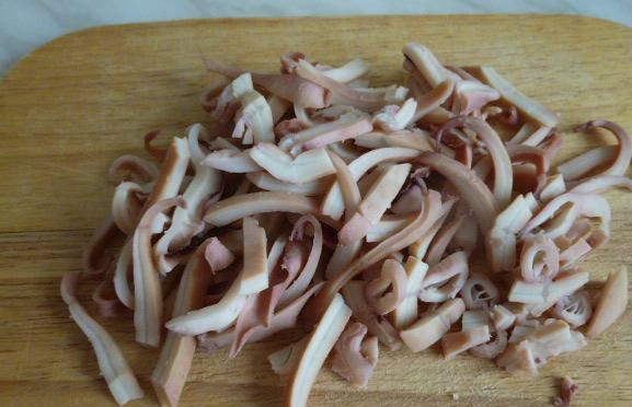 1. Этап. Паста с кальмарами в сливочном соусе: Тушки кальмаров вымойте и высушите бумажным полотенцем. Вычистите все внутренности и прожилки. Разрежьте кальмаров на кольца или полукольца.