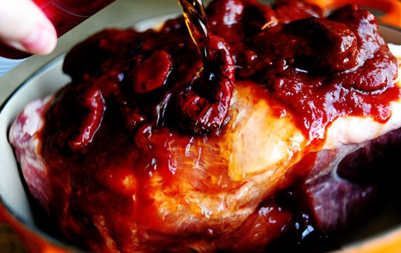 1. Этап. Рулетики с запеченной свининой: 2. Поместите крупно нарезанный лук на дно кастрюли, туда же положите свинину, залейте ее колой.