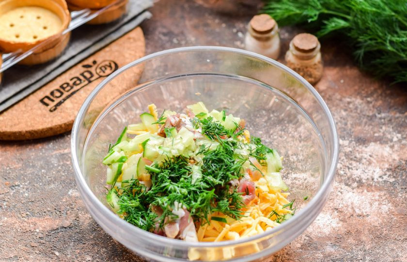 1. Этап. Тарталетки с беконом и сыром: Укроп накрошите, свежий огурец нарежьте небольшими кубиками и добавьте к сыру.