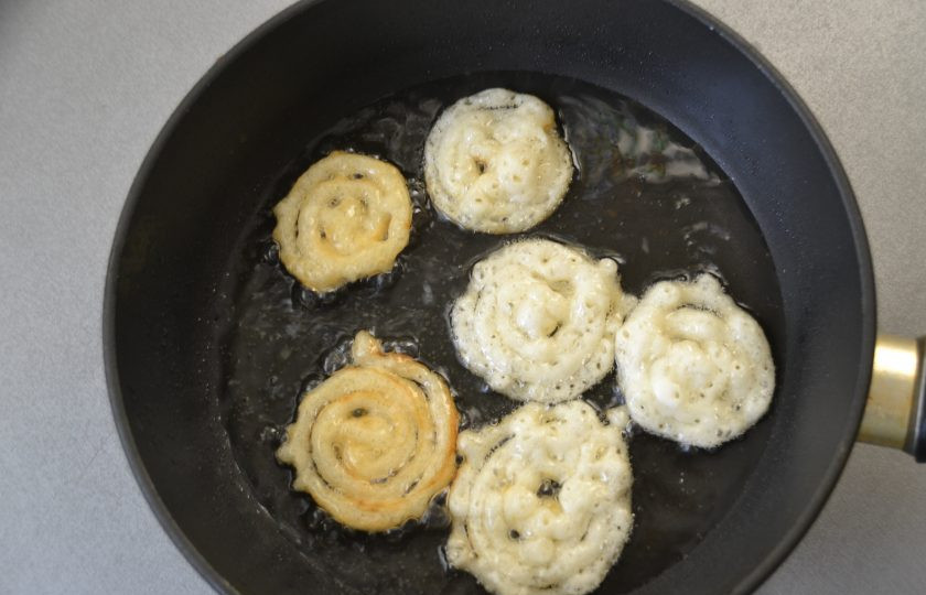 1. Этап. Хворост из жидкого теста: В сковородку налейте растительное масло и хорошо его разогрейте, срежьте у мешка кончик и выдавливайте тесто в масло в виде концентрических колец.