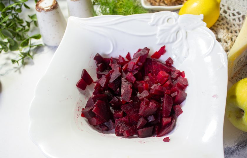1. Этап. Салат со свеклой, сыром и яблоком: Остывшую свеклу очистите и нарежьте небольшим кубиком. Отправьте в салатник.