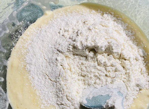 1. Этап. Ватрушки с творогом: Добавить вторую часть муки, замесить лопаткой, чтобы тесто отставало от лопатки