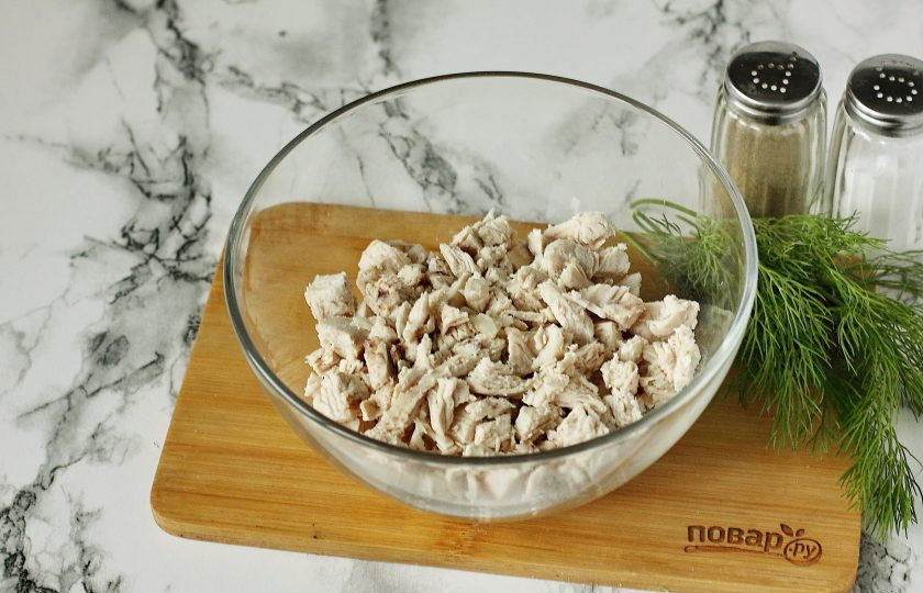 1. Этап. Салат Старый Новый год: Нарежьте куриное филе небольшими кубиками и сложите в глубокую миску.