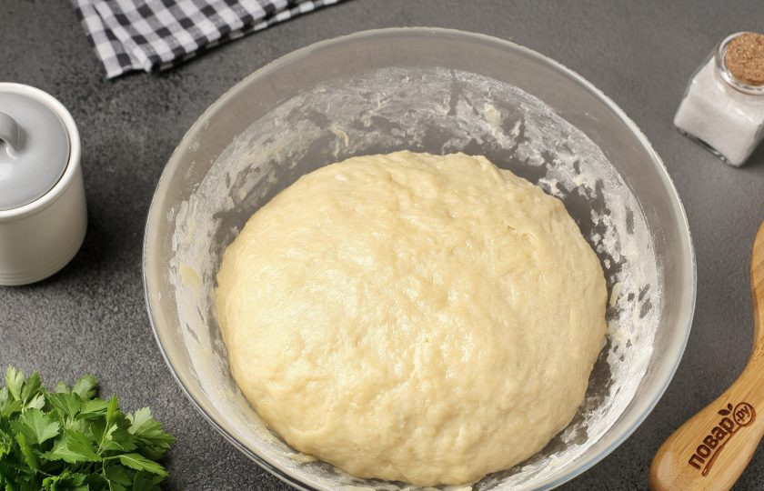 1. Этап. Дрожжевое тесто на подсолнечном масле для печёных пирожков: Затем частями подсыпая оставшуюся муку, замесите мягкое и чуть липкое тесто. Муки может уйти чуть больше или меньше, чем указано в рецепте. По консистенции тесто должно быть похоже на мочку уха. Дотроньтесь до мочки своего уха. Вот таким должно быть и тесто. Соберите его в шар, миску накройте пищевой плёнкой и оставьте в тёплом месте на 1-1,5 часа.