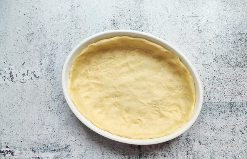 1. Этап. Пирог Ананда: Выложите тесто в форму для выпечки и распределите тесто, сделав бортики.