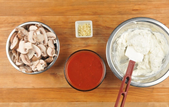 1. Этап. Рулеты с грибами и шпинатом: 2. Чеснок мелко нарубите. Соус смешайте с 1/3 стакана воды. Промытые шампиньоны нарежьте слайсами. К рикотте мелко натрите половину моцареллы, также добавьте соль и перец. Сырную смесь перемешайте.