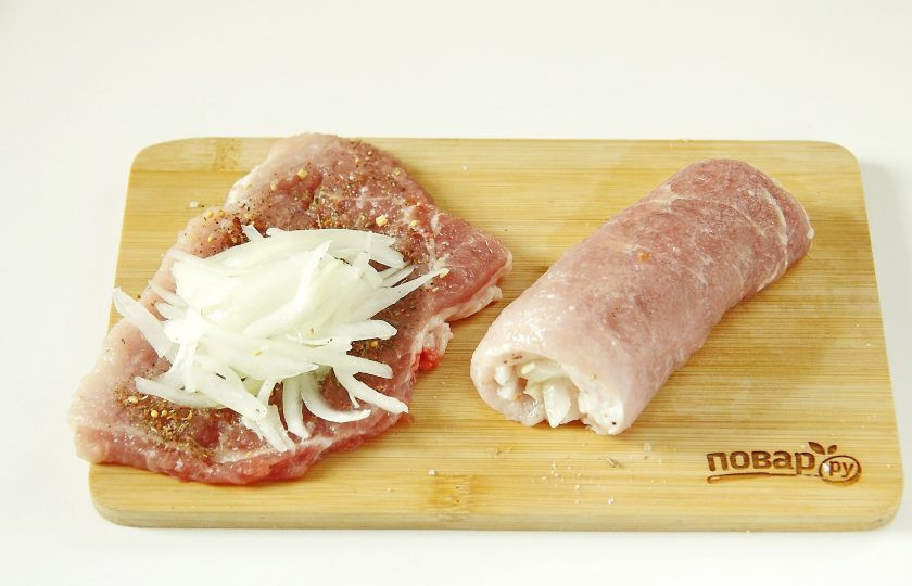 1. Этап. Мясные рулетики с луком: На каждую отбивную положите большое количество лука, чтобы можно было мясо свернуть рулетиком.