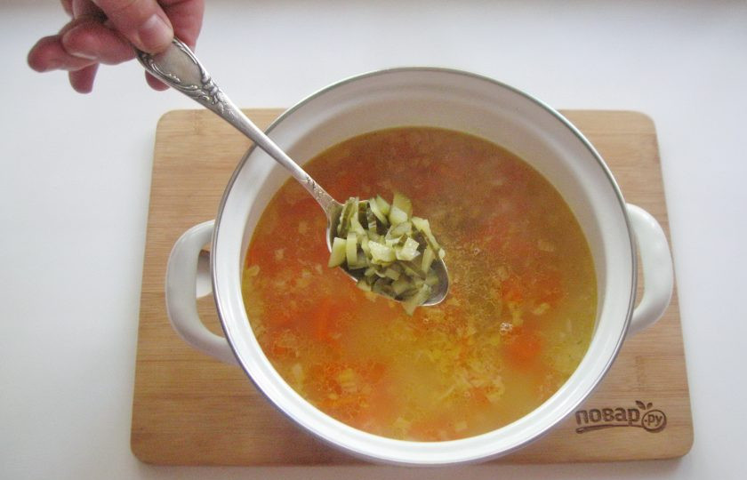 1. Этап. Рассольник без картошки: Когда рис будет готов, добавьте в кастрюлю нарезанный соленый огурец.
