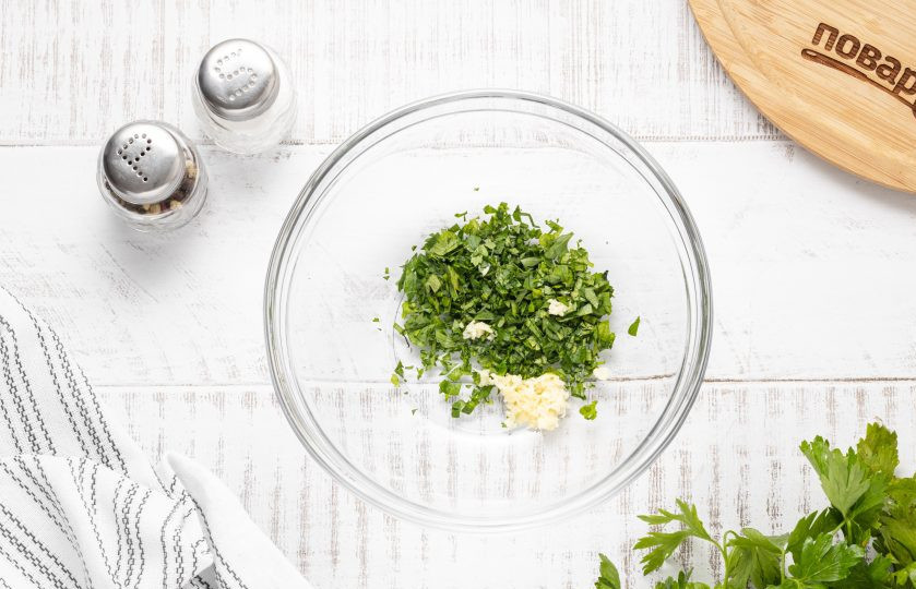 1. Этап. Баклажаны в духовке: Измельчите чеснок и мелко порубите зелень. Переложите в миску.