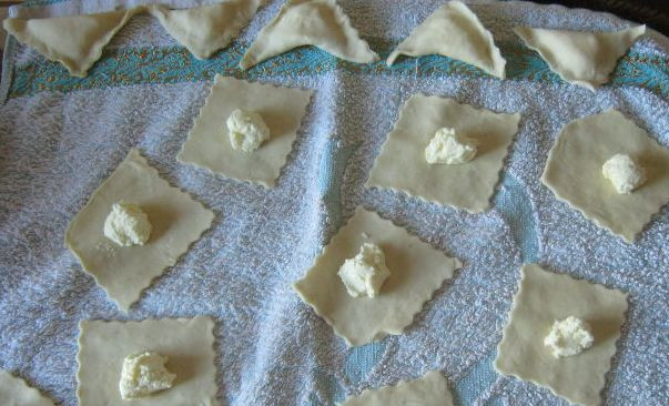1. Этап. Домашние вареники с творогом: В середину каждого квадратика выложите творог. Плотно сожмите края теста пальцами.