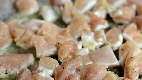 1. Этап. Паста с Песто и курицей: 1. В большой глубокой сковороде разогрейте оба вида масла. Выложите в него курицу, нарезанную кубиками. Обжарьте её в течение 5 минут, пару раз перевернув.