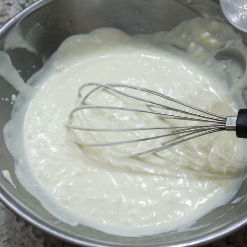 1. Этап. Кокосовое желе с манго: При помощи венчика перемешиваем сливочную массу с желатином.