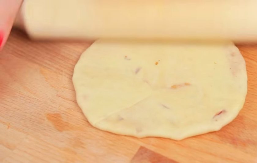 1. Этап. Индийские лепешки с начинкой: 4. Далее разделите тесто на небольшие шарики и каждый раскатайте в тонкий пласт. Выложите в центр начинку и защипните края, сформировав пирожок. Затем снова раскатайте пирожок в тонкий пласт.