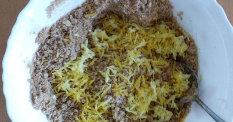 1. Этап. Выпечка из толокна: Смешайте сначала все сухие ингредиенты, если овсяные хлопья слишком крупные, измельчите их в блендере, добавьте ванилин по вкусу, а также специи: кардамон, корицу, мускатный орех. Если хотите, измельчите парочку звездочек гвоздики и тоже добавьте их в смесь. Потом вбейте яйцо, а также влейте масло и замесите тесто. Натрите в него цедру лимона и добавьте тертый имбирь, перемешайте. Получается песочное тесто, которое лучше замешивать руками.