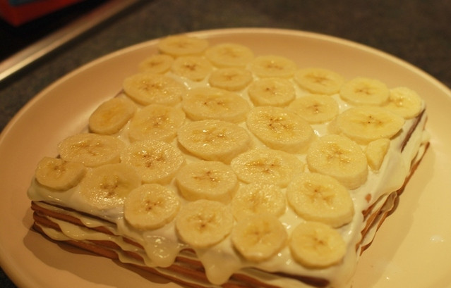 1. Этап. Творожный торт из печенья: Четвертый слой намажьте творожной массой. Если используете творог, лучше предварительно взбить его в блендере, чтобы крупинок не было и он легче намазывался. Банан порежьте и выложите сверху на творог, потом — снова творожную массу поверх банана.