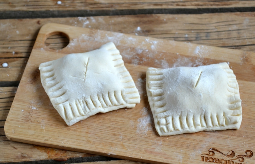 1. Этап. Слойки с вишней из слоеного теста: Сложите тесто и скрепите края вилкой. Верх пирожка смажьте взбитым яйцом.